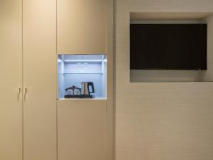 a kitchen with a refrigerator with a television in it at Regente Hotel in Madrid