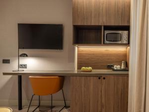 a kitchen with a desk with a microwave and a chair at Regente Hotel in Madrid +126 photos