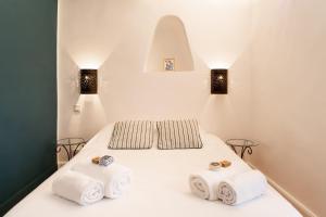 a bedroom with a white bed with towels on it at Casa Marina in Saint-Florent