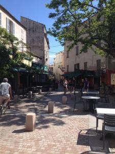 a city street with people riding bikes and tables at Casa Marina in Saint-Florent