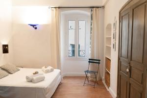 a bedroom with a bed and a chair and a window at Casa Marina in Saint-Florent
