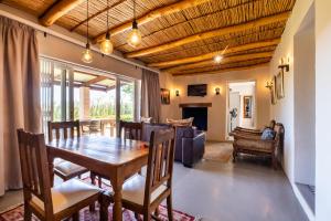 a dining room with a table and a couch at Dorpsig Cottage in Paarl