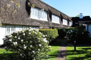 a house with a thatched roof with a pathway at Stutenhof-Wohnung-06 in Keitum