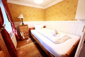 a small bedroom with a bed and a lamp at Ferienhaus-„Alte-Schmiede“ in Westerland