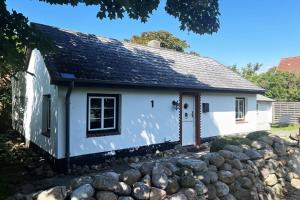 a small white cottage with a stone wall at Ferienhaus-„Alte-Schmiede“ in Westerland