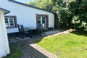 a patio with a table and chairs in a yard at Ferienhaus-„Alte-Schmiede“ in Westerland +3 photos