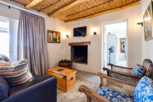 a living room with a couch and a fireplace at Dorpsig Cottage in Paarl