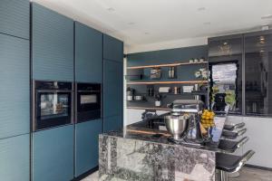 a kitchen with blue cabinets and a counter top at Harderwold Villa - 372 in Zeewolde