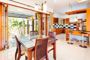 a dining room with a glass table and chairs at Dapur Caringin Tilu Villa in Arcamanik
