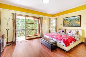a bedroom with a bed and a large window at Dapur Caringin Tilu Villa in Arcamanik