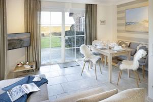 a living room with a table and chairs and a couch at Listend Blick in List