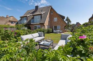 a garden with two couches and a table in front of a house at Listend Blick in List