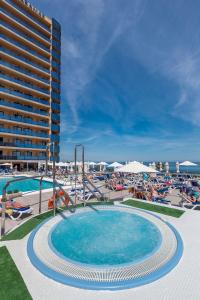 a swimming pool with a hotel and a resort at Hotel Yaramar - Adults Recommended in Fuengirola
