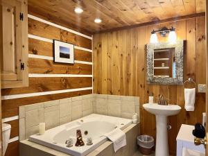 a bathroom with a bath tub and a sink at Hemlock Hill Cabin in Blowing Rock +41 photos