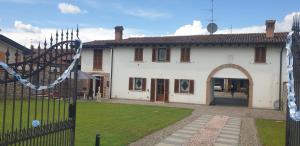 a white house with a gate and a yard at Bracchi's room franciacorta in Cazzago San Martino
