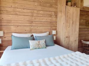 a bedroom with a white bed with wooden walls at Le Petit Oingt de Paradis Chambre d'hôtes in Oingt