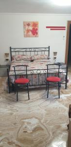 a bedroom with a bed with two chairs in front of it at Bracchi's room franciacorta in Cazzago San Martino +24 photos