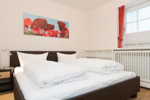 a bedroom with two beds with white pillows at Haus-Meerblick in Rantum