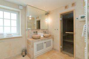 a bathroom with two sinks and a large mirror at Haus-Meerblick in Rantum +28 photos