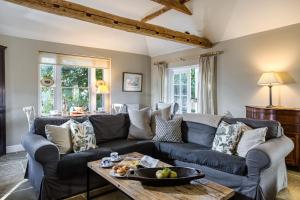 a living room with a blue couch and a table at The Cottage in Steeple Bumpstead