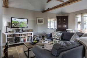 a living room with a couch and a tv at The Cottage in Steeple Bumpstead