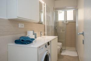 a bathroom with a washing machine and a sink at Finalpia suite con box auto e deposito bici in Finale Ligure +15 photos