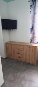 a wooden entertainment center with a flat screen tv on it at Apartament u Piotrusia i Paulinki in Stronie Śląskie