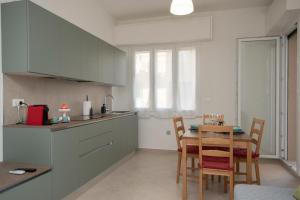 a kitchen with a table and chairs in a room at Finalpia suite con box auto e deposito bici in Finale Ligure