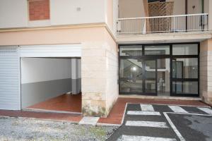 a building with a garage and a balcony at Finalpia suite con box auto e deposito bici in Finale Ligure