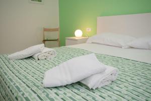 a bedroom with two beds with towels on them at Finalpia suite con box auto e deposito bici in Finale Ligure