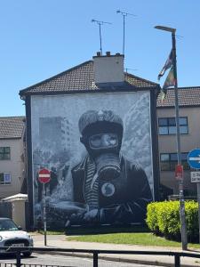 a large painting of a person wearing a gas mask at Limewood Townhouse in Londonderry County Borough