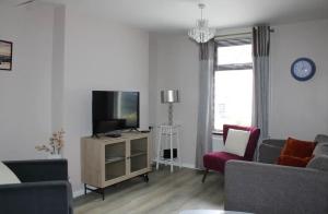 a living room with a couch and a tv at Limewood Townhouse in Londonderry County Borough