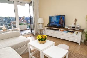 a living room with a tv on a entertainment center at Norderhoog-Whg-45-2-OG-O-Wohnung-45 in Westerland