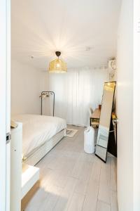 a white bedroom with a bed and a mirror at 코지룸 in Seoul