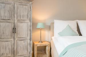 a bedroom with a large wooden cabinet next to a bed at Bandomir-Bungalow-Wohnung-02 in Westerland