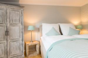 a bedroom with a bed and a wooden cabinet at Bandomir-Bungalow-Wohnung-02 in Westerland