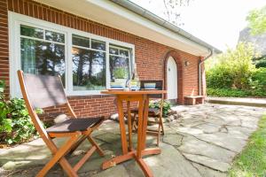 a table and two chairs in front of a house at Bandomir-Bungalow-Wohnung-02 in Westerland
