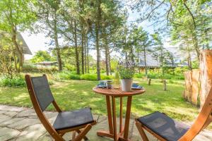 a table with two chairs and a table with a cup of coffee at Bandomir-Bungalow-Wohnung-02 in Westerland