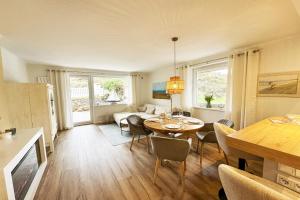 a kitchen and living room with a table and chairs at Haus-Excelsior-Wohnung-08 in Rantum +17 photos