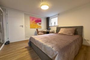 a bedroom with a bed and a desk and a window at Haus-Excelsior-Wohnung-08 in Rantum