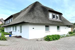 a thatch roofed house with a thatched roof at Haus-Excelsior-Wohnung-08 in Rantum