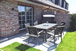 a dining table and chairs on a patio at Haus-Seestern in Tinnum