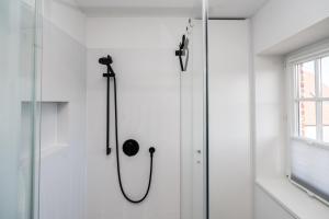 a shower in a white bathroom with a glass door at Haus-Friesenperle in Westerland