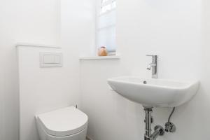 a white bathroom with a sink and a toilet at Haus-Friesenperle in Westerland +1 photo