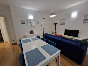 a living room with a blue couch and a table at Il Rifugio di Boccadasse in Genoa