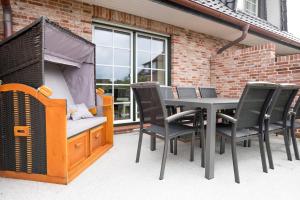 a patio with a table and chairs and a grill at Haus-Seestern in Tinnum