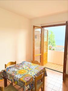 a dining room with a table and a balcony at A montagna e u mari home in Aci Castello
