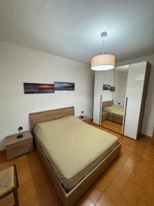 a bedroom with a large bed and a mirror at A montagna e u mari home in Aci Castello