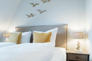 a bedroom with a white bed with birds on the wall at Stadtrose in Westerland