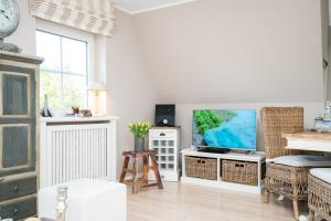 a living room with a flat screen tv on a table at Tunghoern-Hues in Keitum